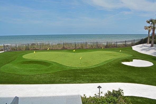 Metro New York Synthetic grass golf green by the sea with yellow flags and a sand bunker